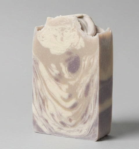 Bar of soap with a decorative stamp on a dark surface